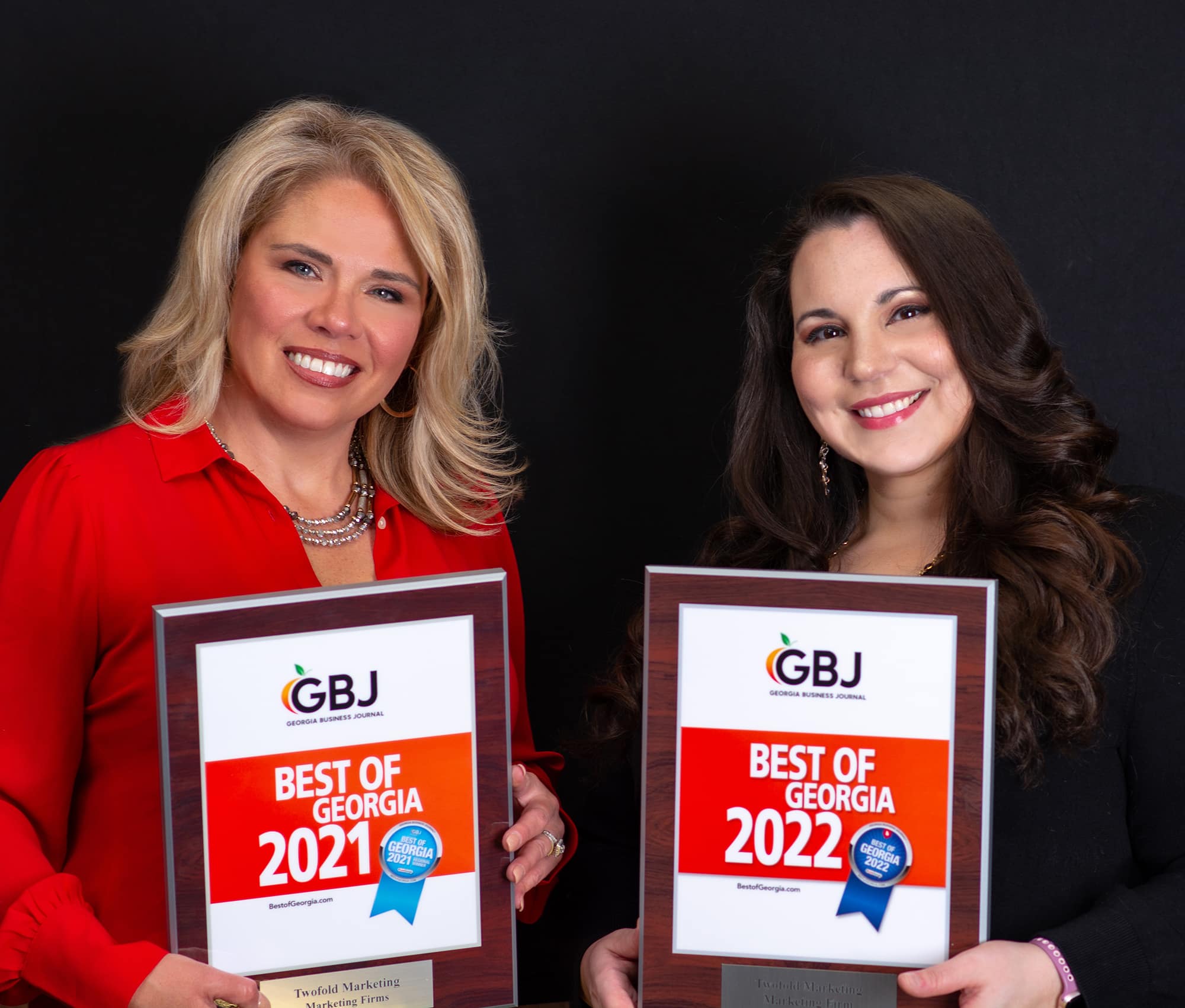 Business owners of Twofold Marketing, Heidi and Jessica, holding the "Best Marketing Agency in Georgia" awards for 2021 and 2022